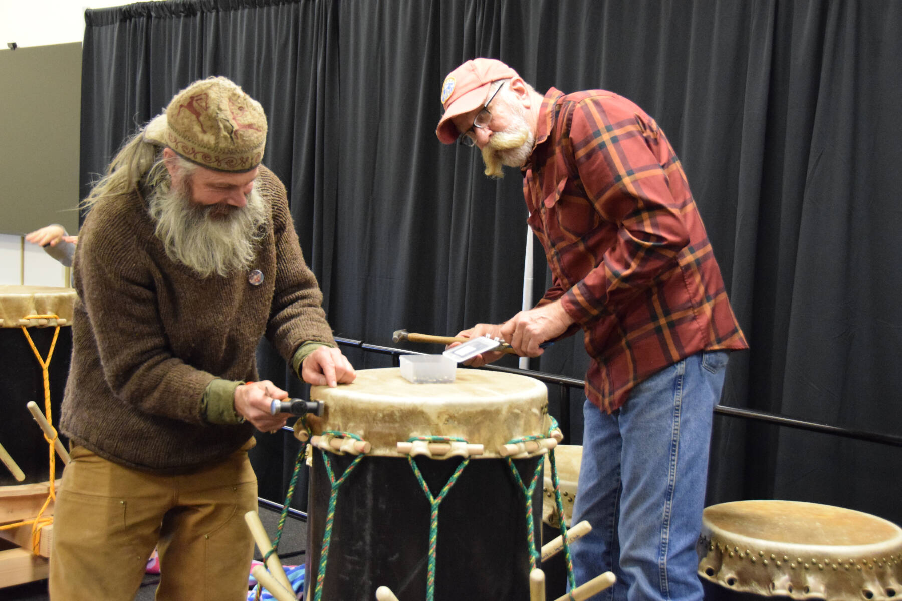 Lasse Holmes (left) and Mark Conrad (right) tack the formed and stretched drumskin onto the taiko drum base during the free workshop hosted at Kachemak Bay Campus on Friday, May 3, 2024 in Homer, Alaska. (Delcenia Cosman/Homer News)