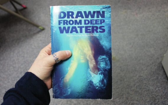 Ashlyn O’Hara/Peninsula Clarion
A copy of “Drawn from Deep Waters: True Stories from the Kenai Peninsula,” is held on Thursday in Kenai.