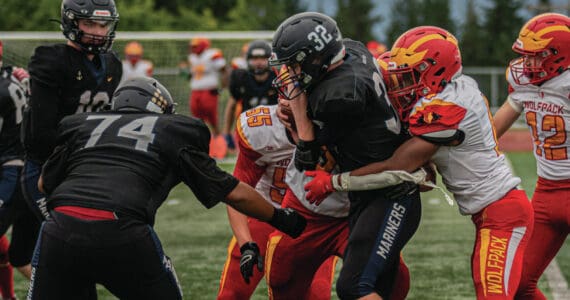 Homer High School mariner varsity football player Jackson Snaric, #32, junior returning a kickoff during the August 30, 3034 night bout against the visiting Fairbanks West Valley Wolfpack on the mariner field. He is assisted by Ellington Dudley, #74, junior. (Photo provided by Wilhelm Hakala, Homer High School yearbook staff)