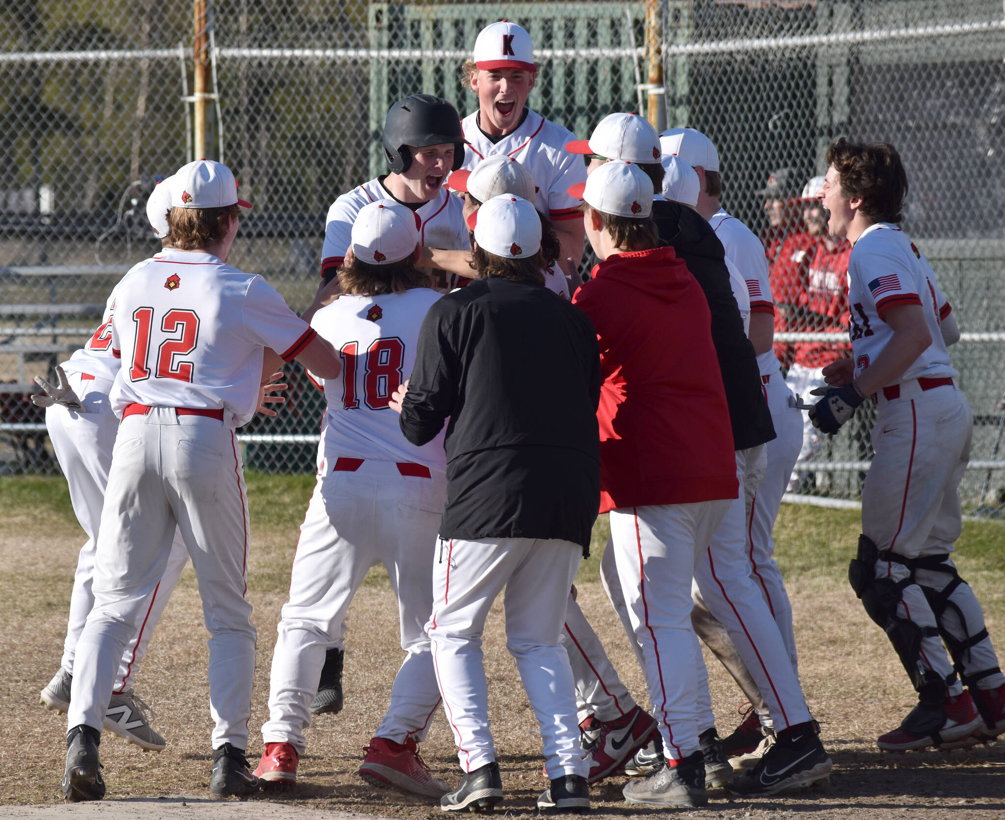 Kenai Central’s Daniel Steffensen (wearing batting helmet) and teammates celebrate Steffensen’s home run Friday, May 9, 2025, at the Kenai Little League fields in Kenai, Alaska. (Photo by Jeff Helminiak/Peninsula Clarion)