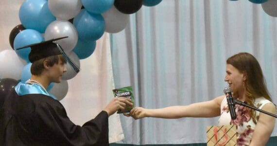 Guest speaker Donica Nash gave out candy matching each student, including this package of JOYRIDE to Gideon Pankratz, at the River City Academy graduation ceremony Tuesday, May 20, 2025, at Skyview Middle School just outside of Soldotna, Alaska. (Photo by Jeff Helminiak/Peninsula Clarion)