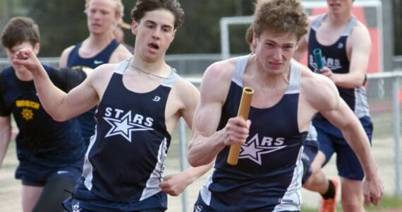 Soldotna's Tyce Escott hands to James Innes in the 400-meter relay Saturday, May 17, 2025, at the Kenai Peninsula Borough meet at Ed Hollier Field at Kenai Central High School in Kenai, Alaska. (Photo by Jeff Helminiak/Peninsula Clarion)