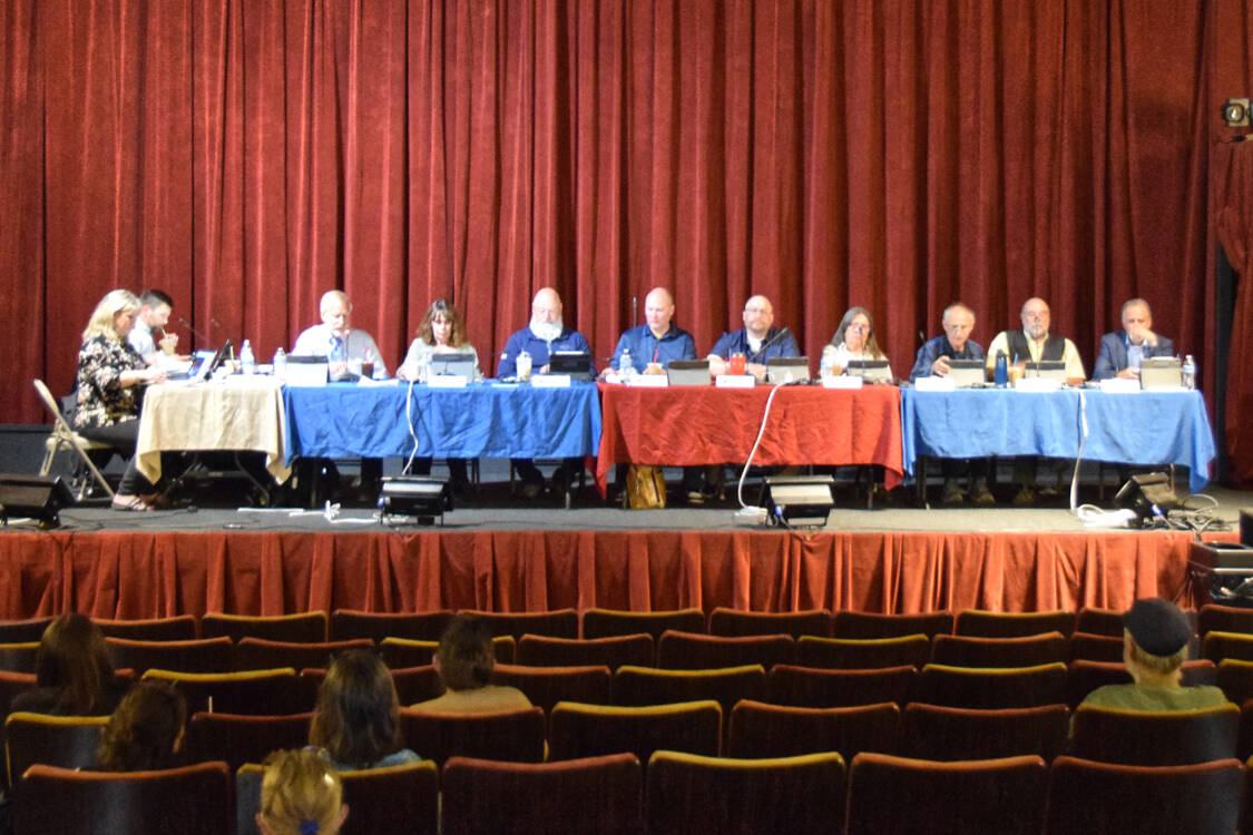 The Kenai Peninsula Borough Assembly gathers before the beginning fo the Aug. 5, 2025, KPB Assembly meeting at the Porcupine Theater in Homer, Alaska. (Chloe Pleznac/Homer News)