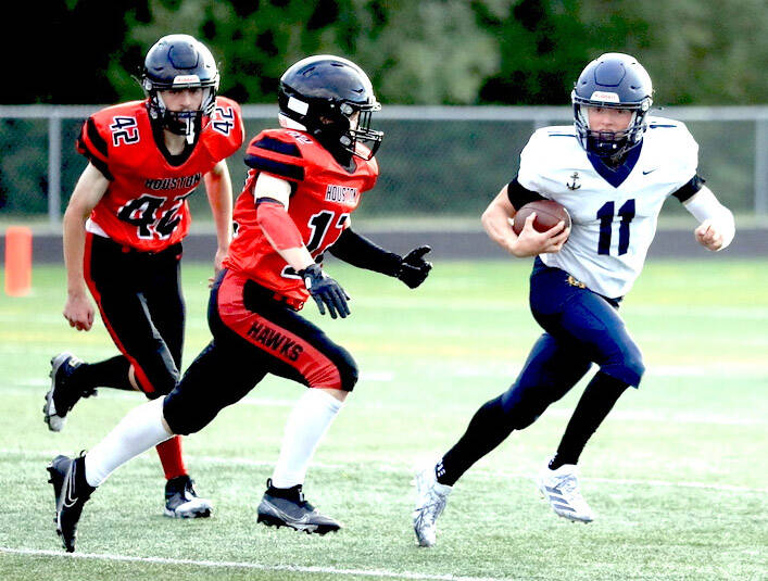 Homer’s Justus Grimes shifts past a pair of Houston Hawks en route to a kickoff return for a touchdown of more than 80 yards during the second half of a 64-8 win over the Hawks on Friday, Aug. 15, 2025, at Houston High School in Houston, Alaska. (Bruce Eggleston/matsusports.net)