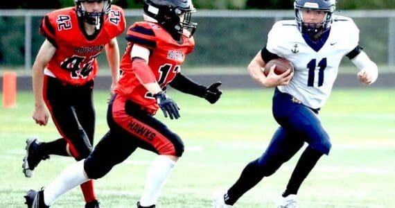 Homer's Justus Grimes shifts past a pair of Houston Hawks en route to a kickoff return for a touchdown of more than 80 yards during the second half of a 64-8 win over the Hawks on Friday, Aug. 15, 2025, at Houston High School in Houston, Alaska. (Bruce Eggleston/matsusports.net)