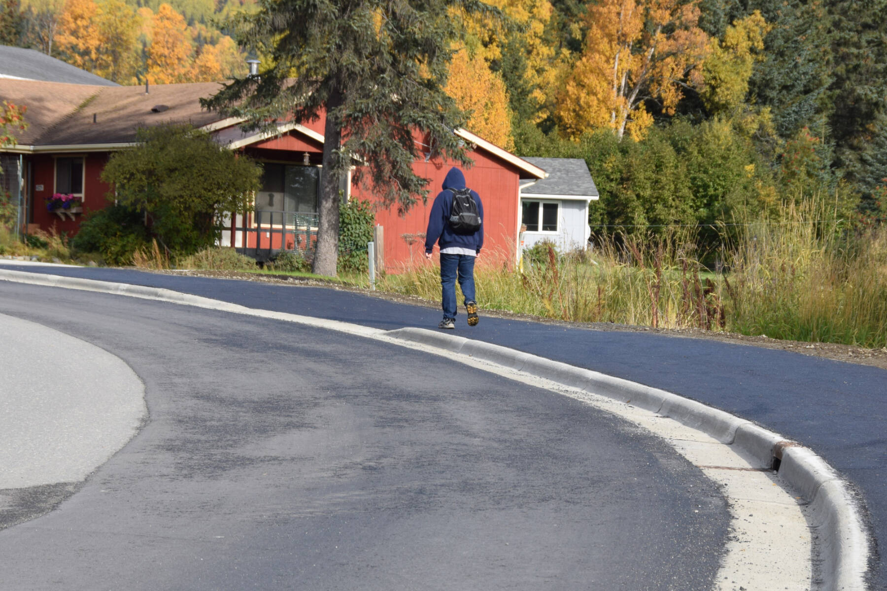 A local community member walks up Ben Walters Lane on a newly completed sidewalk on Monday, Sept. 30, 2024, in Homer, Alaska. (Delcenia Cosman/Homer News)