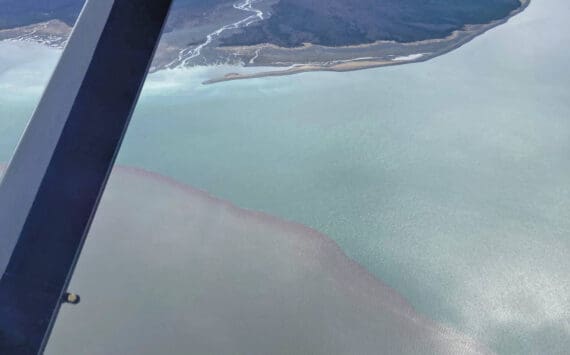 This photo taken Beryl Air pilot Stephanie Greer on Friday, May 21, 2021, over Grewingk Glacier and Glacier Spit shows the mesodinium rubrum bloom to the left as contrasted with the normal ocean water of Kachemak Bay near Homer. (Photo courtesy of Stephanie Greer/Beryl Air)