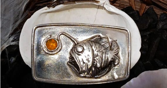 "The Angler Fish" is a handcrafted sterling silver brooch by artist Carley Conemac that features a silver clay angler fish and a Mexican fire opal inset, and is on display in Conemac's exhibit at Homer Council on the Arts through October. Photo provided by Carley Conemac