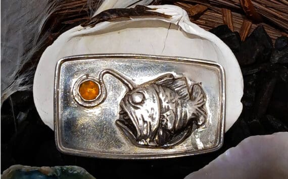 "The Angler Fish" is a handcrafted sterling silver brooch by artist Carley Conemac that features a silver clay angler fish and a Mexican fire opal inset, and is on display in Conemac's exhibit at Homer Council on the Arts through October. Photo provided by Carley Conemac