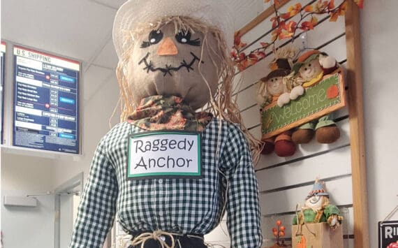 A friendly scarecrow stands on the counter at the Anchor Point Post Office in October 2025 in Anchor Point, Alaska. (Delcenia Cosman/Homer News)