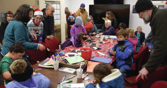 Kids and parents craft holiday ornaments during at the Homer Chamber of Commerce and Visitor Center during their annual Christmas tree lighting celebration on Thursday, Dec. 5, 2024, in Homer, Alaska. (Delcenia Cosman/Homer News)