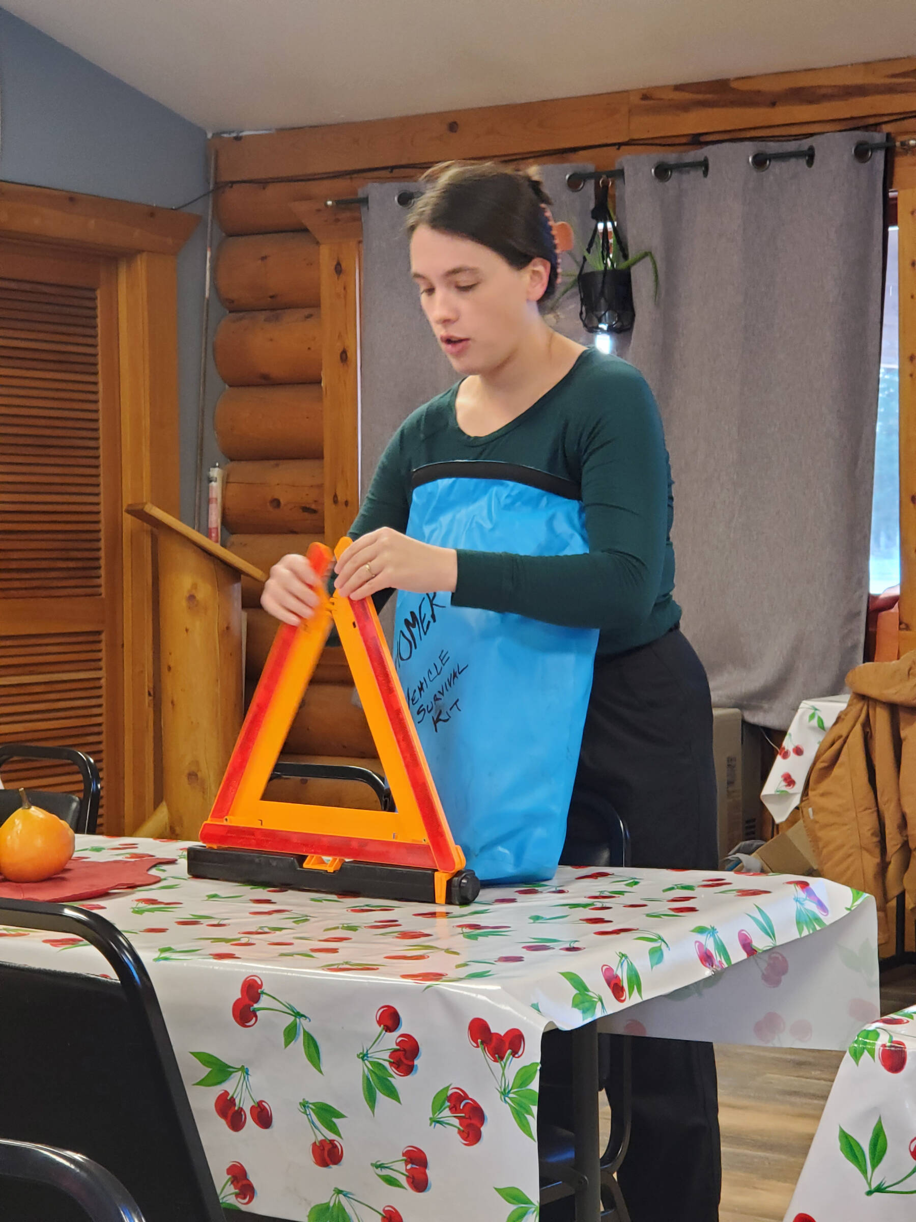 Homer public health nurse Emily Sears demonstrates tools in her vehicle emergency supply kit during a presentation on winter storm preparedness at the Anchor Point Senior Center on Thursday, Nov. 20, 2025, in Anchor Point, Alaska. (Delcenia Cosman/Homer News)