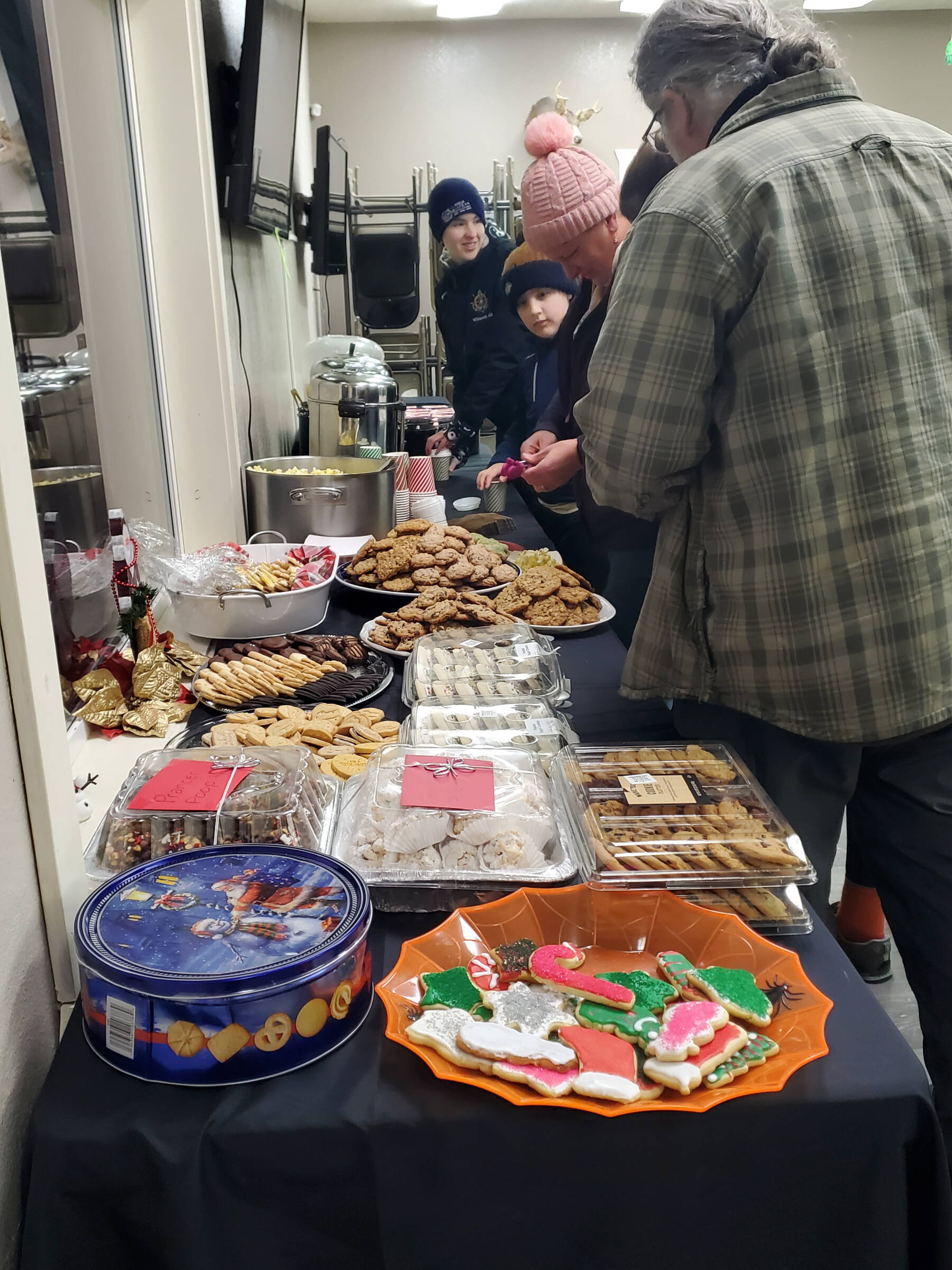 Community members enjoy a cookie and hot cocoa bar at the VFW Post 10221 after the Christmas tree lighting ceremony on Saturday, Dec. 6, 2025, in Anchor Point, Alaska. (Delcenia Cosman/Homer News)