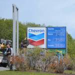 A worker with Prism Design and Construction, Wasilla, on Thursday, May 31, installs Chevron signs at the Essential One gas station on the Sterling Highway and Poopdeck Street. (Photo by Michael Armstrong/Homer News)