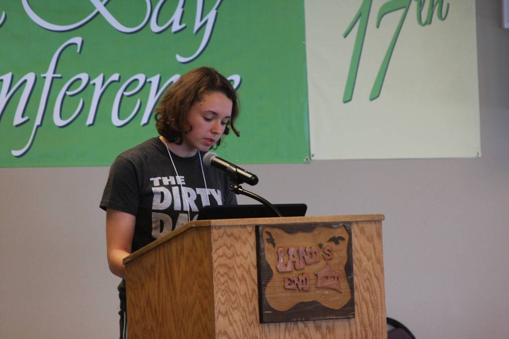 Homer resident Ellie Sythe reads chapter one from her action/adventure novel, On the Wings of a Nightingale, at the open mic session on Monday, June 11, 2018 at the Kachemak Bay Writers Conference at Lands End Resort in Homer, Alaska. (Photo by Delcenia Cosman)