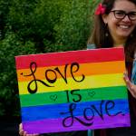 Kevyn Jalone shows a sign she carried in the Pride March on Saturday, June 23, 2018 in Homer, Alaska. (Photo by Michael Armstrong/Homer News)