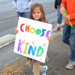 Cate Davis, 8, marches down Pioneer Avenue with sign that reads Choose kind, on Saturday, June 23, 2018 during Homers first ever Pride March in Homer, Alaska. Davis fathers were some of the organizers of the March. (Photo by Megan Pacer/Homer News)