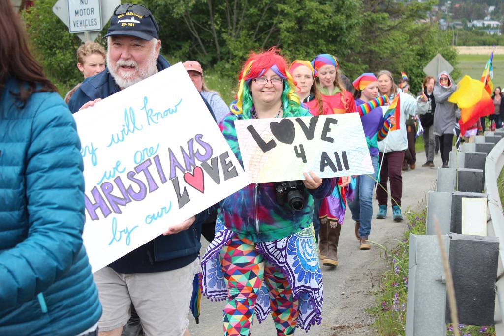 Participants in the Saturday, June 23, 2018 Pride March walk along Ocean Drive in Homer, Alaska with signs that read: They will know we are Christians by our love, and Love 4 all. About 280 people turned out for the inaugural march. (Photo by Megan Pacer/Homer News)