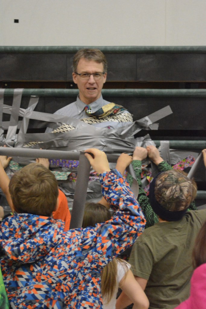 West Homer Elementary Principal Eric Waltenbaugh gets duct taped to the wall in the multipurpose room. Students at West Homer and Fireweed Academy got the reward of plastering duct tape across the principals for filling up a jar with tokens handed out when a student showed good behavior like being respectful and responsible.
