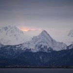 A faint ray of sun glows over Poot Peak at sunrise on Tuesday morning. Snow has covered the higher elevations of the chocolate-drop shaped mountain, showng the iconic panda bear face seen in the mountain side.