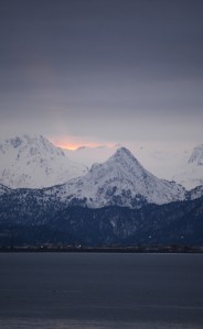 A faint ray of sun glows over Poot Peak at sunrise on Tuesday morning. Snow has covered the higher elevations of the chocolate-drop shaped mountain, showng the iconic panda bear face seen in the mountain side.