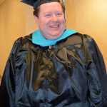 Terry Rensel poses for a photo after receiving a master of public administration at Kachemak Bay Campus commencement last Wednesday.