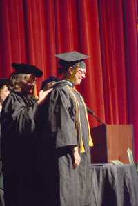 University of Alaska Regent Lisa Parker confers the master of education hood for early childhood special education on Hanna Young during Kachemak Bay Campus commencement last Wednesday.