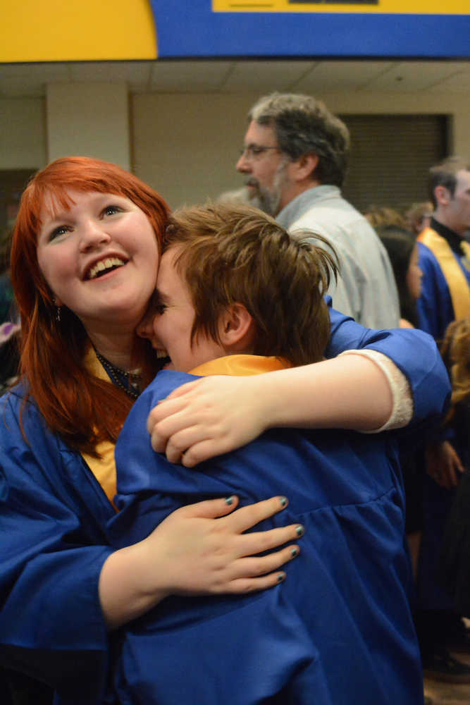 Sabina Karwowski, left, hugs her friends, Becca Seneff, after Homer High School graduation on Tuesday.