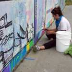 Kady Perry works on the Heath Street mural last Friday.