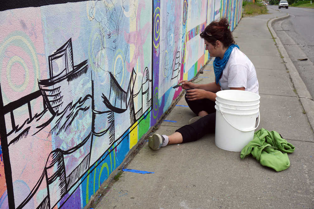 Kady Perry works on the Heath Street mural last Friday.