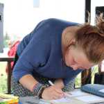 Laurel Glaves, a sophomore at Homer High School, writes words of support to the Orlando, Fla. LGBTQ community in a book during the Love for Orlando event at WKFL Park on Friday, June 17. "I heard about what happened and my friends had a moment of silence and cried for a little," Glaves said. "It's really beautiful seeing the Homer community coming together."