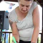 Homer City Council member Catriona Reynolds creates a bright border on a piece of paper in the scrapbook of encouragement put together by the participants at Love for Orlando on Friday, June 17.