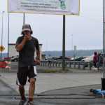 Homer resident Marlin Schuster, 31, crosses the finish line of the Spit Run in third place with a time of 0:37:24.56.