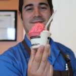Carmen Ricciardi holds out a freshly scooped cup of Tahitian vanilla bean gelato and raspberry sorbetto in his shop Carmen's Gelato.