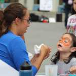 Alexandra Jones, 6, closes her eyes as Aleta Phelps works on a face painting design at the South Peninsula Hospital 60th Anniversary Party on Saturday, July 9.