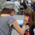 Brandi Scott paints four-year-old Erica Koch's face during the South Peninsula Hospital 60th Anniversary Party on Saturday, July 9.