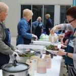 Homer Medical Center employee Crystal Rogers pours dressing over the salad accompanying the ribs on her lunch plate at the South Peninsula Hospital 60th Anniversary Party. Black Jaxx BBQ provided lunch for attendees of the Saturday, July 9 celebration.