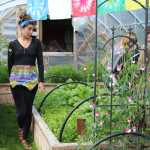 Drue Smith walks inside the Solstice Tunnel, a greenhouse at Synergy Gardens, during a July 10 farm tour.