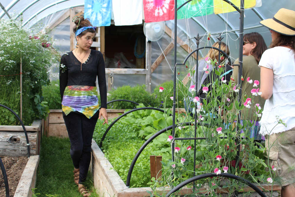 Drue Smith walks inside the Solstice Tunnel, a greenhouse at Synergy Gardens, during a July 10 farm tour.