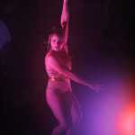 Quixotic aerialist and dancer Megan Stockman hangs from a spinning hoop suspended over the stage at Salmonfest in the early hours of Sunday, August 7. Quixotic uses dance and aerial acts as part of their unique performance style.