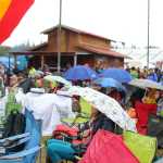 Festival guests sit under umbrellas and use tarps to keep dry while enjoying the music at Salmonfest on a rainy Saturday, August 6.