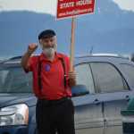 Rep. Paul Seaton, R-Homer, waves campaign signs at the corner of Lake Street and Pioneer Avenue on Tuesday.