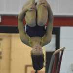Rhythm Beckett-Cook of Homer curls up tight as she completes her dive Friday at the Kenai Swim Invite at Kenai Central High School.