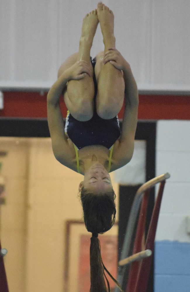 Rhythm Beckett-Cook of Homer curls up tight as she completes her dive Friday at the Kenai Swim Invite at Kenai Central High School.