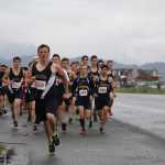 Boys cross-country runners from Homer, Nikolaevsk, Kenai, Voznesenka, Port Graham, Nikiski and Soldotna take off from Pier One Theatre to run five kilometers to the base of the Spit in the Homer Spit Trials on Saturday, Sept. 17. The weather stayed gray all morning, forcing the boys and girls teams to run in the rain.