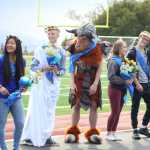 (left to right) Members of the 2016 Homer High School homecoming court Lady Abby Middleton; Prince Koby Etzwiler stands with a student dressed as the Ancient Greek monster, the minotaur, who stood in for absent Princess Maggie Box; and King Martin Welty and Queen Samantha Jacobsen pose for a photo at the homecoming game on Saturday, Sept. 24. The Parade of the Classes had a theme of Ancient Greece this year.