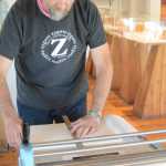 Claudio Orso-Giacone prepares a wood block to make a print during his residency at Bunnell Street Arts Center last month. The printing press was donated to Bunnell by the estate of Homer artist Gaye Wolfe.
