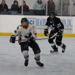 Homer Mariner Ethan Pitzman skates down the ice with Chugiak player Zachary Krajnik on his heels during Homer and Chugiak's Saturday afternoon game at Kevin Bell Arena.