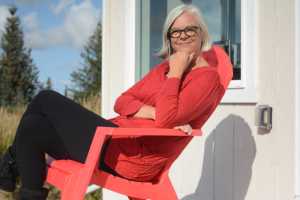 Kim Steutermann Rogers sits on the deck of Frederica, a small cabin on the Storyknife writers retreat property.