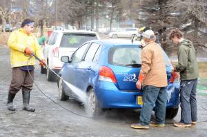 Defying breakup Zach Condon, left, washes the car of a Homer High School Mariners baseball team supporter at a fundraiser on Saturday at Wells Fargo. Baseball team members and supporters washed away a winter&rsquo;s worth of grime. Helping him are, middle, Austin Dash, and right, Seth Adkins. &ldquo;For me this makes it like spring is coming,&rdquo; said Lotus Condon, the mother of baseball player Zach Condon. &ldquo;Baseball. Car washes.&rdquo;